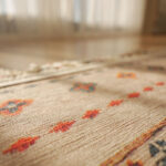 A patterned rug rests on the flooring beside a mirror.